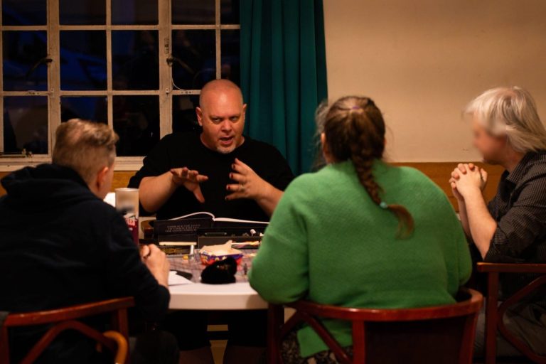 Four people are sitting around a table talking.